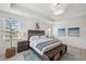 Bright bedroom with tray ceiling, light wood floors, and a blue accent rug and bench at the foot of the bed at 32490 Tree Of Life Ave, Wesley Chapel, FL 33543