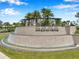 Community entrance sign with stone waterfall feature and lush landscaping, creating a welcoming atmosphere at 32490 Tree Of Life Ave, Wesley Chapel, FL 33543