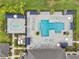 Aerial view of a community pool with multiple sunbeds, shade structures, and splashpad at 32490 Tree Of Life Ave, Wesley Chapel, FL 33543