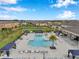 Aerial view of a community pool area with ample seating, shade structures, and lush landscaping in a residential neighborhood at 32490 Tree Of Life Ave, Wesley Chapel, FL 33543