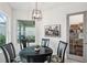 Cozy dining area featuring a black table, pendant lighting, and a view of the screened lanai at 32490 Tree Of Life Ave, Wesley Chapel, FL 33543