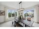 Dining room featuring modern light fixture and windows offering a view of the backyard and screened-in pool at 32490 Tree Of Life Ave, Wesley Chapel, FL 33543