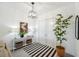 Bright entryway with modern lighting, decorative rug, console table, and a potted plant, creating an inviting ambiance at 32490 Tree Of Life Ave, Wesley Chapel, FL 33543