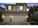 A well-lit, two-story home featuring a paver driveway, an attached three-car garage, and manicured landscaping at 32490 Tree Of Life Ave, Wesley Chapel, FL 33543