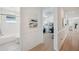 The hallway is lined with neutral walls and frames the bathroom, living spaces, and bedrooms at 32490 Tree Of Life Ave, Wesley Chapel, FL 33543