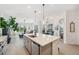 Open kitchen featuring an island with a sink, gray cabinets, and seamless transition to the dining area at 32490 Tree Of Life Ave, Wesley Chapel, FL 33543