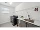 Modern laundry room with sleek appliances and a well-organized folding area at 32490 Tree Of Life Ave, Wesley Chapel, FL 33543