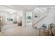 Open-concept living room featuring staircase and view of kitchen island, offering bright and modern living at 32490 Tree Of Life Ave, Wesley Chapel, FL 33543