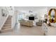 An open-concept living area offers a staircase, stylish furniture, and views of the outdoor patio at 32490 Tree Of Life Ave, Wesley Chapel, FL 33543