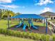 Modern community playground with blue shade cover, multiple slides, climbing structures, and bench seating at 32490 Tree Of Life Ave, Wesley Chapel, FL 33543