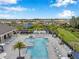 Aerial view of a community swimming pool with lounge chairs and lush landscaping at 32490 Tree Of Life Ave, Wesley Chapel, FL 33543