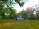 Scenic shot of the home with a large lot, shaded by mature trees and surrounded by greenery at 4210 Garden Ln, Tampa, FL 33610