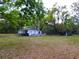 Exterior view of a charming home with a spacious yard, offering a peaceful and private setting at 4210 Garden Ln, Tampa, FL 33610