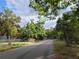 Street view of the property with mature trees creating a peaceful and shaded environment at 4210 Garden Ln, Tampa, FL 33610