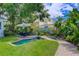 Lush backyard oasis with a charming water feature, tropical landscaping, and cozy patio seating at 4742 13Th N Ave, St Petersburg, FL 33713