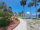 Picturesque waterfront view featuring a charming walking path, shady gazebos, and tropical palm trees at 4851 W Gandy Blvd # B12L23, Tampa, FL 33611