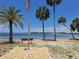 Scenic waterfront view with palm trees, beach, and serene water, perfect for relaxation at 4851 W Gandy Blvd # B12L23, Tampa, FL 33611