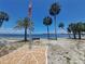 Scenic waterfront view with palm trees, beach, and serene water, perfect for relaxation at 4851 W Gandy Blvd # B12L23, Tampa, FL 33611