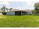 Spacious backyard with lush green grass, complete with screened-in lanai and fenced yard at 4959 Cromey Rd, North Port, FL 34288