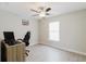 Bedroom featuring a ceiling fan and neutral paint, with wood-look tiling and a desk at 4959 Cromey Rd, North Port, FL 34288