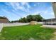 Grassy backyard featuring a shed, privacy fence, screened patio and sunny sky at 5015 Summer Hill Dr, Zephyrhills, FL 33542