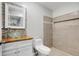 Bathroom with a vessel sink on a wood vanity, toilet, and tiled walk-in shower at 5015 Summer Hill Dr, Zephyrhills, FL 33542