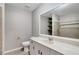 Bathroom with a wide mirror, modern vanity, toilet, and tiled walk-in shower at 5015 Summer Hill Dr, Zephyrhills, FL 33542