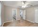 Bedroom with light grey walls, light brown laminate floors, ceiling fan, and an ensuite bathroom at 5015 Summer Hill Dr, Zephyrhills, FL 33542