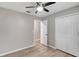 Bedroom with vinyl floors, paneled closet, and a ceiling fan, open to another room at 5015 Summer Hill Dr, Zephyrhills, FL 33542