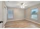 An empty room with light grey walls, a ceiling fan, and light brown laminate floors at 5015 Summer Hill Dr, Zephyrhills, FL 33542