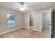 Bedroom with light grey walls, light brown laminate floors, ceiling fan, and an ensuite bathroom at 5015 Summer Hill Dr, Zephyrhills, FL 33542