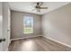 Bright bedroom with modern ceiling fan, light gray walls, wood-look floors, and a window at 5015 Summer Hill Dr, Zephyrhills, FL 33542