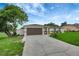 Charming single-story home features a two car garage, well-manicured lawn, and mature tree in the front yard at 5015 Summer Hill Dr, Zephyrhills, FL 33542