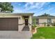 Close up of the house showing well-maintained landscaping, updated exterior paint, and a dark colored front door at 5015 Summer Hill Dr, Zephyrhills, FL 33542