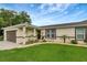 Landscaped front yard with updated paint and garage door is accented by a luscious green lawn at 5015 Summer Hill Dr, Zephyrhills, FL 33542