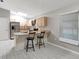 Bright kitchen features stainless steel appliances, light wood cabinetry, and eat-in counter with pendant lighting at 5015 Summer Hill Dr, Zephyrhills, FL 33542