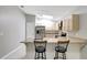 Bright kitchen features stainless steel appliances, light wood cabinetry, and eat-in counter with pendant lighting at 5015 Summer Hill Dr, Zephyrhills, FL 33542