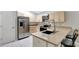 Bright kitchen features stainless steel appliances, light wood cabinetry, and eat-in counter with pendant lighting at 5015 Summer Hill Dr, Zephyrhills, FL 33542