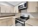 Bright kitchen features stainless steel appliances, light wood cabinetry, and eat-in counter with pendant lighting at 5015 Summer Hill Dr, Zephyrhills, FL 33542