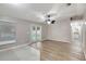 Spacious living room with modern flooring, fresh paint, ceiling fan, and French doors leading to the backyard at 5015 Summer Hill Dr, Zephyrhills, FL 33542