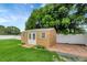 Backyard shed with double doors, windows and a small deck surrounded by green grass at 5015 Summer Hill Dr, Zephyrhills, FL 33542
