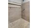 Walk-in shower featuring light stone-look tile, a river rock floor, and a built-in shelf at 5015 Summer Hill Dr, Zephyrhills, FL 33542