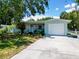 Charming single-story home with a well-manicured front yard, a white picket fence and attached one car garage at 5600 Hobson Ne St, St Petersburg, FL 33703
