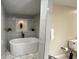 Luxurious bathroom featuring a stand alone soaking tub, tiled accent wall and modern fixtures at 5614 Kenny Dr, Tampa, FL 33617