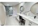 A spacious bathroom is equipped with double vanities, granite countertops, and a glass enclosed shower at 5614 Kenny Dr, Tampa, FL 33617