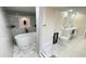A spacious bathroom featuring a soaking tub, glass shower, and double vanity at 5614 Kenny Dr, Tampa, FL 33617