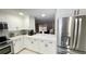 View of kitchen with white cabinets, stainless steel refrigerator, and quartz countertops at 5614 Kenny Dr, Tampa, FL 33617