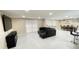 Spacious living room features neutral tile, a black sectional, dining area and media center at 5614 Kenny Dr, Tampa, FL 33617