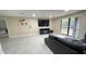 Open living room with large window, tile floor, and wall-mounted TV at 5614 Kenny Dr, Tampa, FL 33617