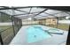Backyard featuring a screened-in pool and spa surrounded by a concrete deck for enjoying outdoor living at 5614 Kenny Dr, Tampa, FL 33617